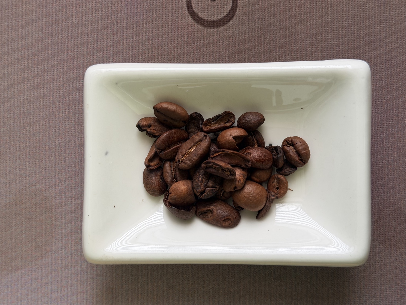 Biji kopi Arabica Commercial Grade di piring putih