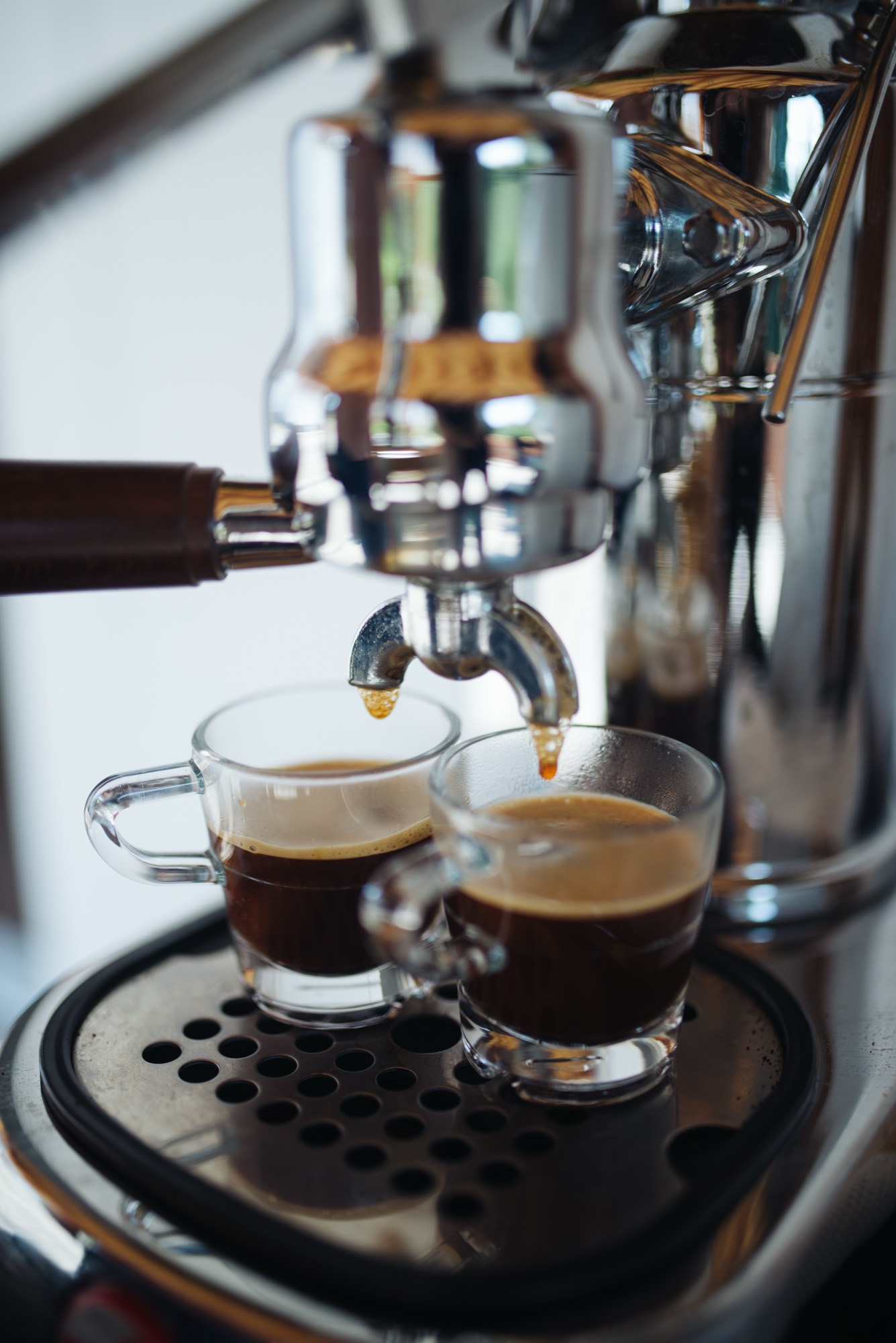 Mesin espresso sedang menyeduh dua cangkir kopi