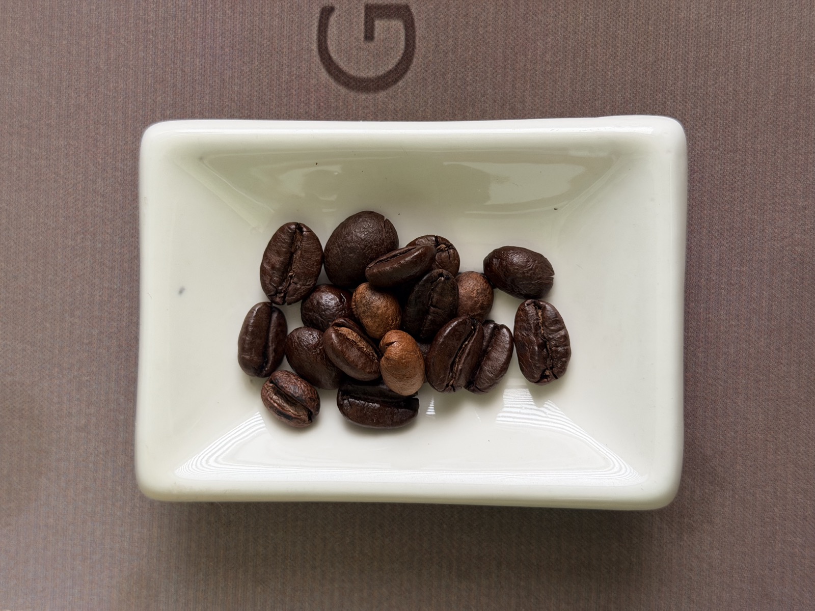 Biji kopi House Blend 70:30 di piring putih